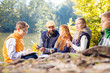 © zinkevych - Beautiful nature. Nice young pupils sitting near the lake while exploring the forest together