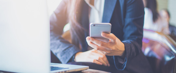 Business woman hand using mobile phone in office.Web banner.