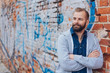 © contrastwerkstatt - Relaxed trendy bearded man with folded arms