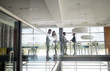 © NDABCREATIVITY - Group of business people walking and taking at stairs in an office