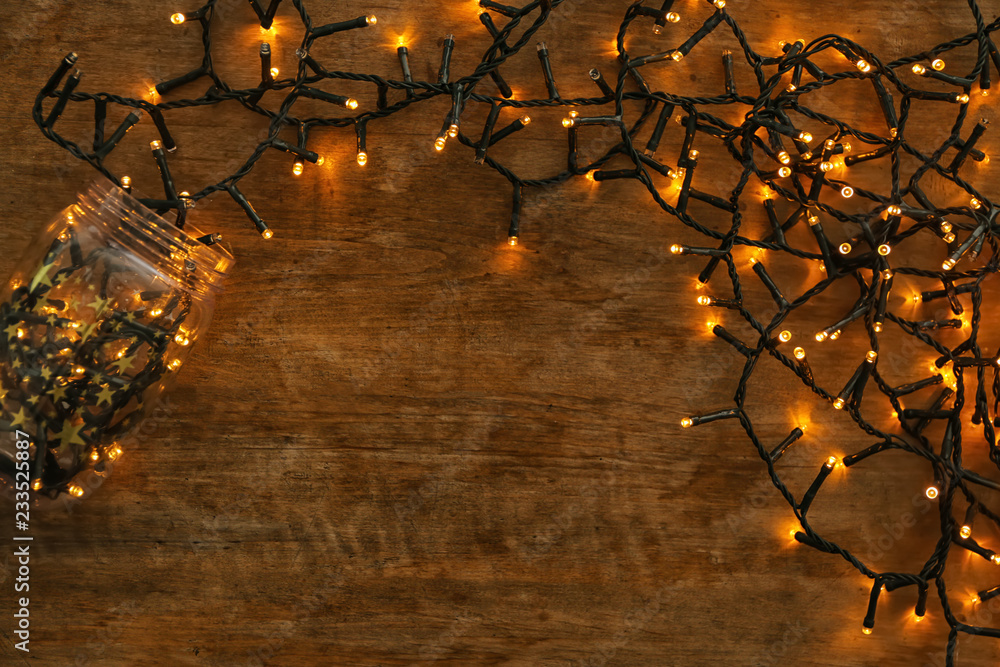 Glowing Christmas lights on wooden table