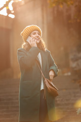 Sticker - Beautiful young woman talking by mobile phone on stairs outdoors