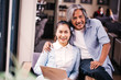 © twinsterphoto - Retired and elderly South East Asian senior male and female couple using computer laptop together on sofa indoors.