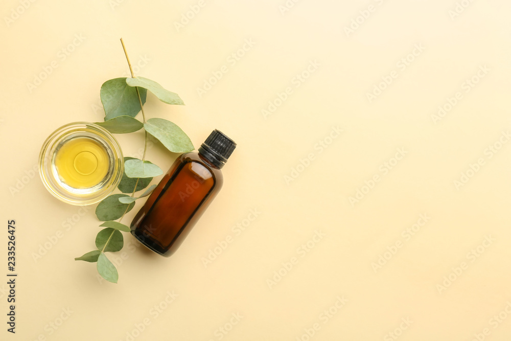 Bottle and bowl with eucalyptus essential oil on color background