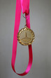 Medal for first place on a bright pink ribbon symbolizing success