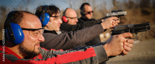 Fotomural Group of people practice gun shooting on outdoor shooting range