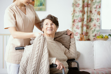 Sticker - Nurse helping smiling elderly woman in the wheelchair during home visit