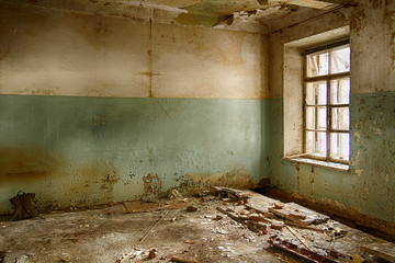 Abandoned and ruined room with broken window and construction garbage on the floor. HDR image