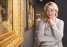 Mature Woman In Art Museum Near The Painting
