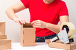 Woman packing cardboard boxes , picking and puttind products