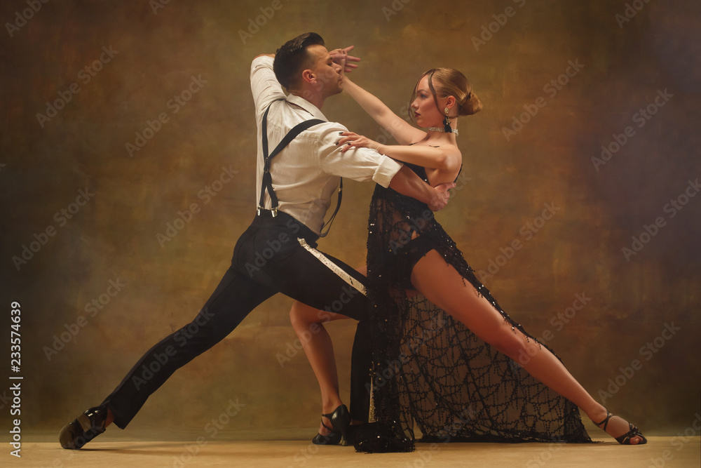 Flexible young modern couple dancing tango in studio. Fashion portrait of attractive dancing couple. Man and woman. Passion. Love. perfect skin facial and make-up. Human emotions - love and passion - obrazy, fototapety, plakaty 