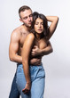 © Алексей Торбеев - Beautiful couple wearing jeans and topless. Man passionately hugs the girl from behind, covering her big breasts with his hands. Casual style. Lifestyle, fashion, commercial design.