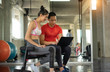 © naruecha - Portrait of young woman signing contract with personal fitness coach in modern gym, copy space
