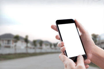 Smartphone blank screen in woman hands over blurred background at urban street.