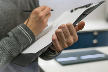 Businessman Holding A Clipboard And Writing