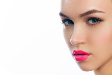 Close-up beauty portrait of a brunette woman with classic arrows on her eyes and a pink border on her lips. Nail makeup and lipstick on perfectly clean skin. Spa treatments and cosmetic injections