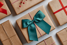 Christmas Presents Wrapped In Brown Paper And Decorated With Bows And Ribbons. From Above