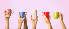 Many Different Hands Holding Multi Colored Cups Of Coffee On A Pink Background. Female And Male Hands. Concept Of A Friendly Team, A Coffee Break, Meeting Friends, Morning In The Team. Banner