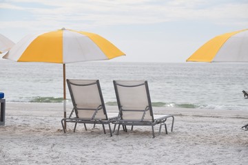 Background with two chairs and umbrella on the beach