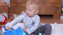 Infant Child Sitting And Playing With Bricks