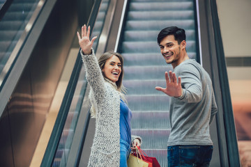 Wall Mural - Happy young couple shopping and holding bags