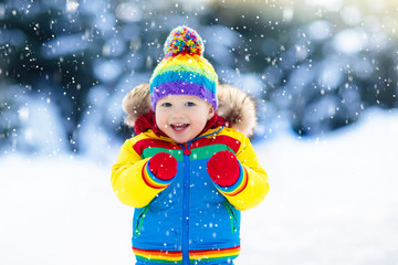 Wall Mural - Child playing with snow in winter. Kids outdoors.