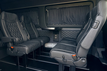 Luxury leather seats in the van. Interior of luxury minivan with open doors