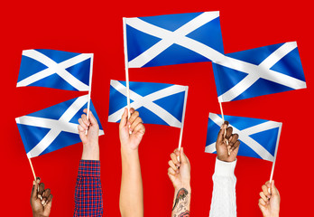 Wall Mural - Hands waving flags of Scotland