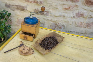 Vintage manual coffee grinder and coffee beans on old wooden table