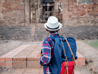 Senior man Asian with backpack are walking at Phra Prang Sam Yot. Ancient and historical attractions and one of the most important archaeology of Lopburi province thailand. Travel, Tourist Concept