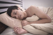 © Mongkon N. Thongsai - Young Asian Caucasian man on bed having insomnia / migraine  / broken / sick / lonely.