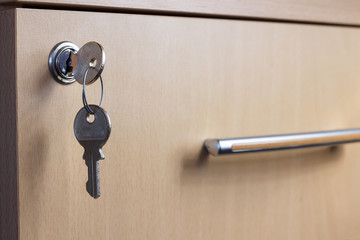 The key in the keyhole of the desk drawer