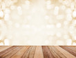 Wood table top over abstract golden background with white bokeh.
