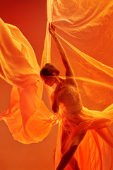 young graceful female ballet dancer or classic ballerina dancing at red studio. caucasian model on p