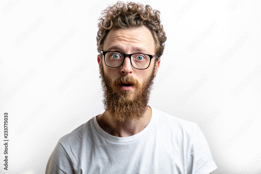 surprised bearded man in spectacles, looks with bated breath and ...
