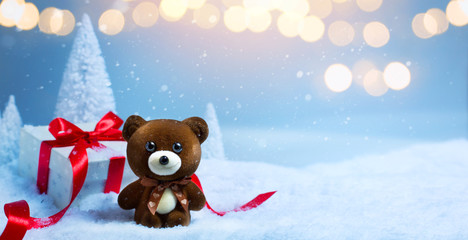 christmas banner background; Christmas tree, cute teddy bear and gift box on snow