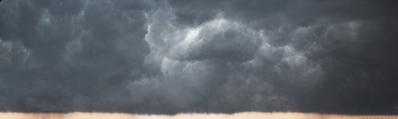 Panorama of cloudy terrifying dark sky before  thunderstorm. Dark dramatic stormy rainy sky.