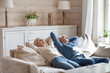 © fizkes - Peaceful elderly couple sleep on cozy couch spending weekend in countryside, calm senior husband and wife relax on sofa dreaming with eyes closed, aged man and woman take a nap resting at home