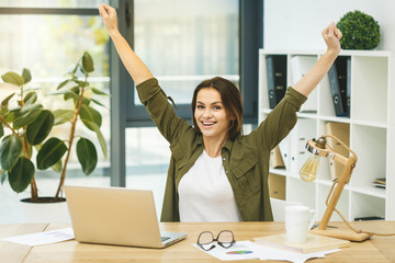 I am a winner! Portrait of young cheerful business woman in smart casual wear having fun and smiling.