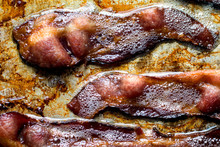 Close Up Of Bacon Frying In Frying Pan