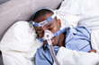 Man Wearing CPAP Mask Sleeping On Bed