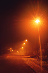 Wall Mural - Night street view with nobody out there at evening mist with orange glow from the street lights. Braunschweig, Germany