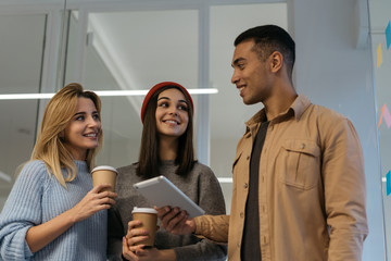 Poster - Group of smiling multiracial university students studying, working project, communication together, learning language holding digital tablet and drinking coffee. Portrait of happy hipster friends.  