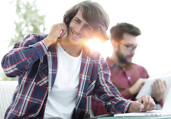 guy with a friend sitting at the desk.