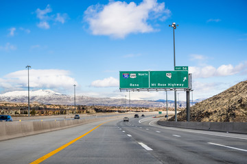 Travelling on the interstate towards Reno; the city's downtown visible in the background; Nevada