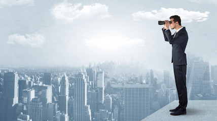 Wall Mural - businessman looking forward to a city with binoculars from skyscraper concept