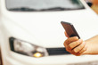 © Rafael Henrique - Man holding cell phone with white car in background