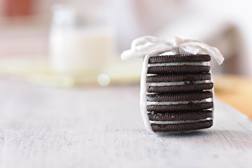 Delicious chocolate cookies whit vanilla cream and fresh glass of milk in background/ Conceptual image of sweet healthy breakfast