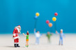 © Sirichai Puangsuwan - Miniature people: Santa Claus and children holding balloon