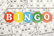 The Word Bingo Made Of Wooden Letters On Bingo Cards Background.